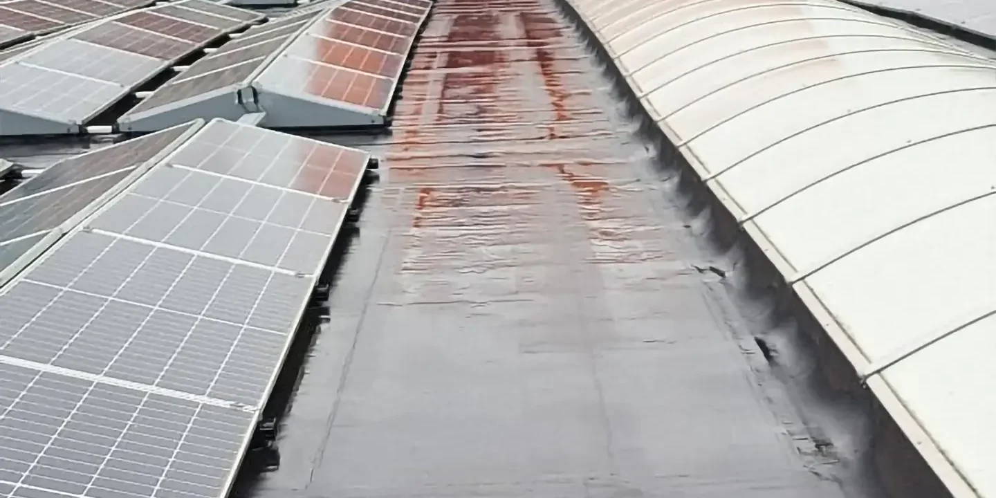 Schoonmaak van dak met zonnepanelen door L-Groep, gericht op het verwijderen van vuil en onderhoud van dakbedekking.
