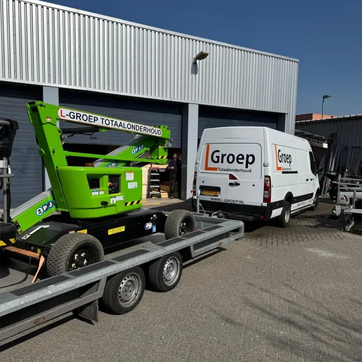 Groene knikgiekhoogwerker van L-Groep Totaalonderhoud voor een werkplaats.