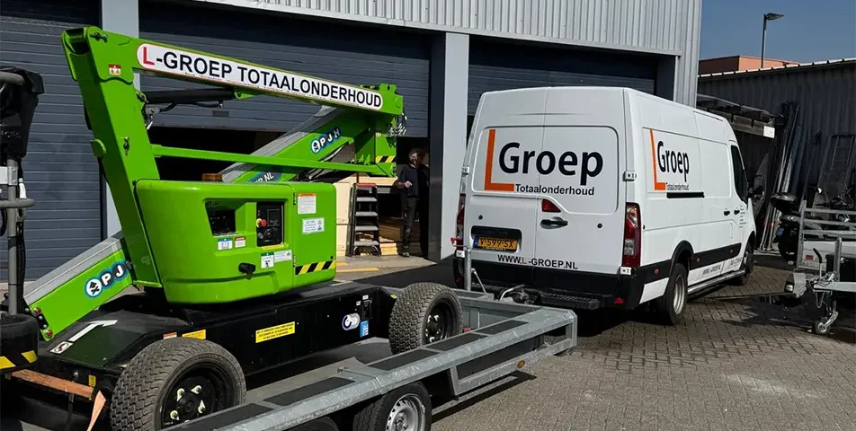 Groene knikgiekhoogwerker van L-Groep Totaalonderhoud voor een werkplaats.